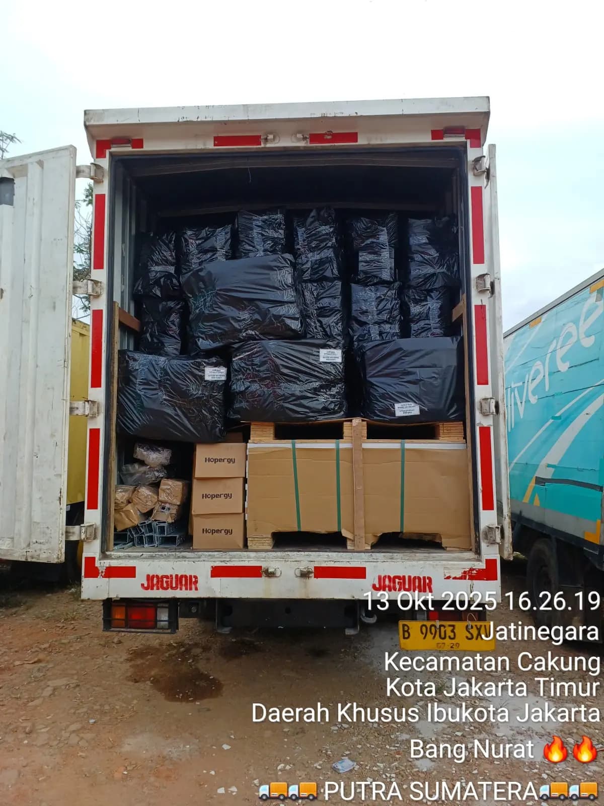 Bagian belakang truk box PSB berisi muatan terbungkus plastik dan palet karton yang sudah diikat